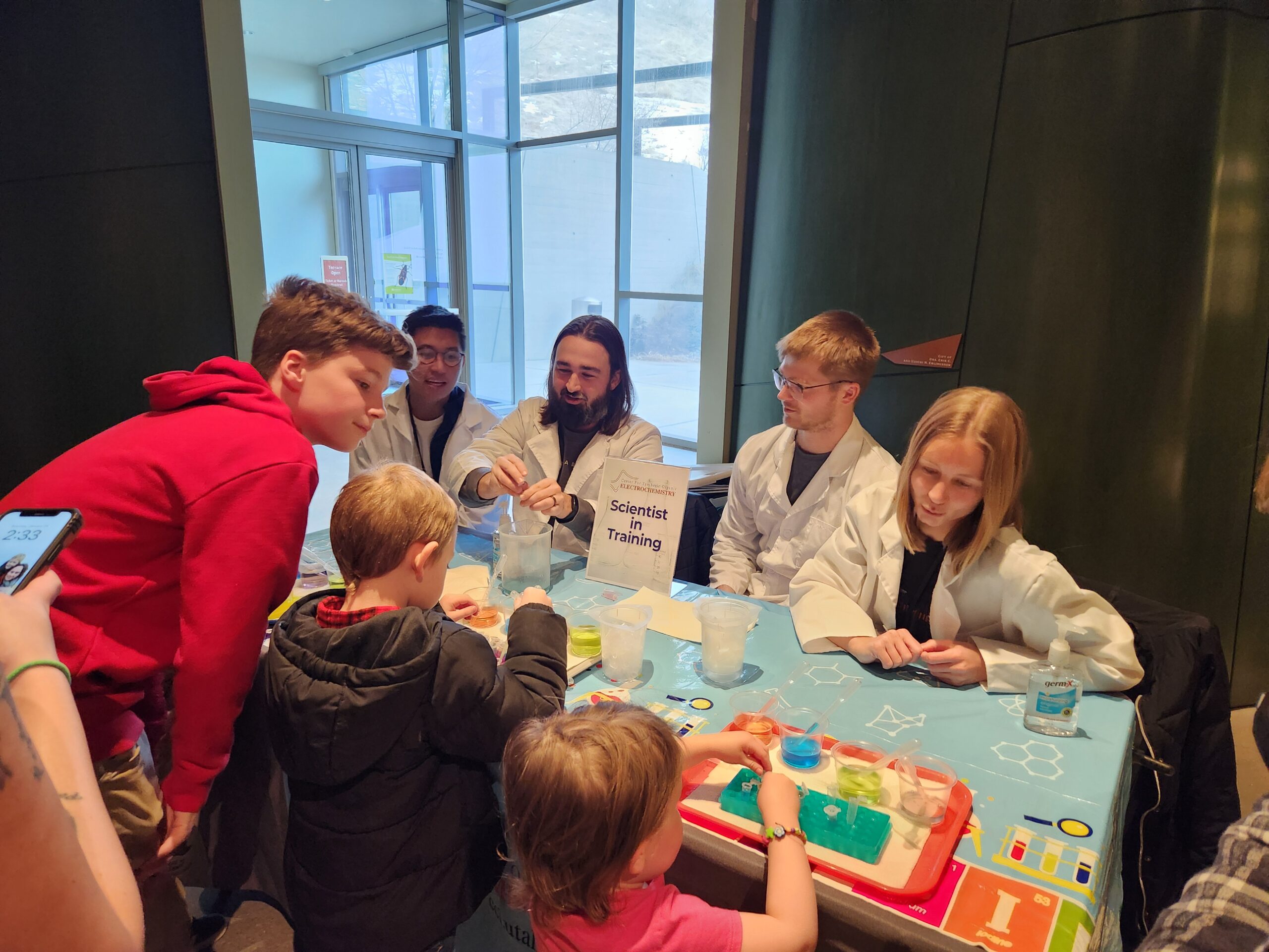 20250125_143326 Scientists guiding students in an experiment at a booth